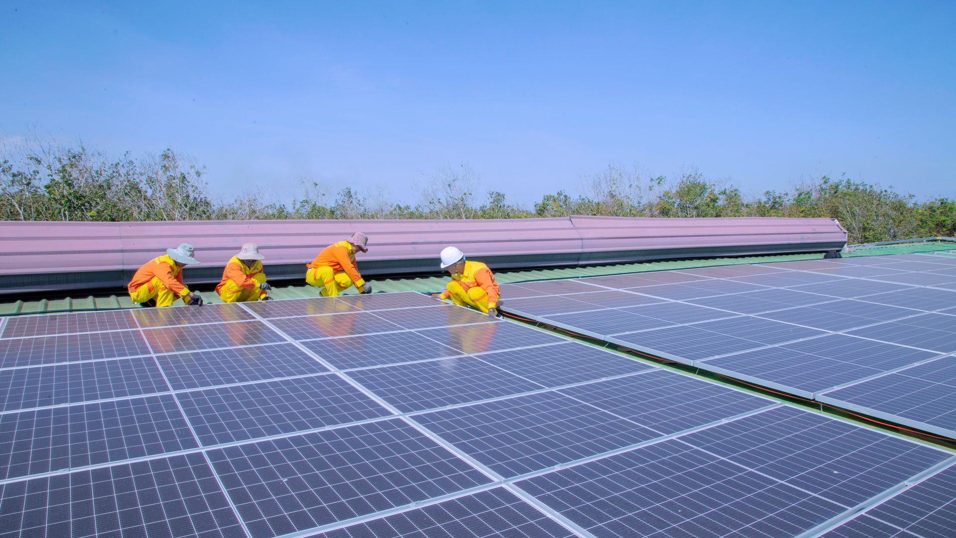 Solar technicians installing photovoltaic panels on a rooftop
